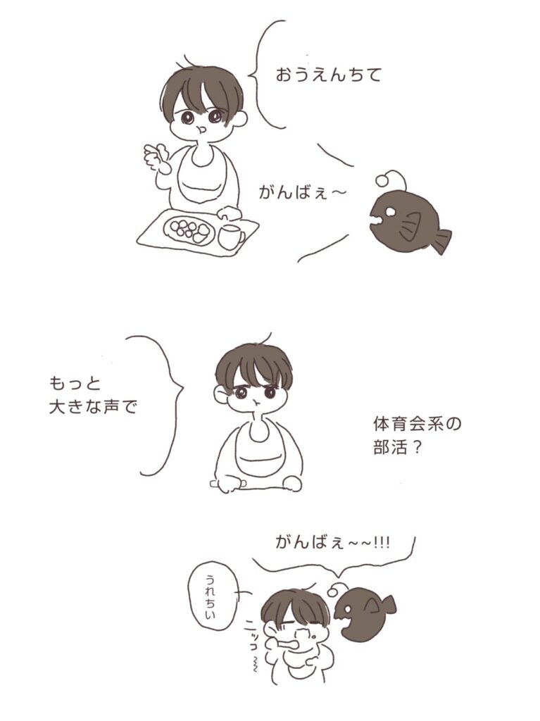 子どもがごはんを食べながら「応援して」と言い、母親が「がんばれ～」と声をかける日本語版の子育て絵日記イラスト。親子の微笑ましい食事シーン。